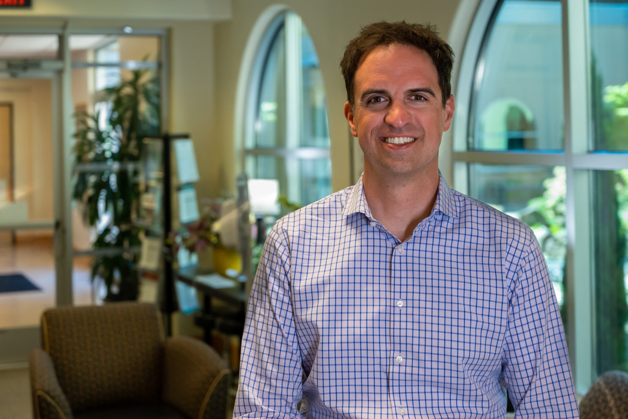 Marquis home office employee Director of Operations standing and smiling at the Marquis home office in Milwaukie, OR