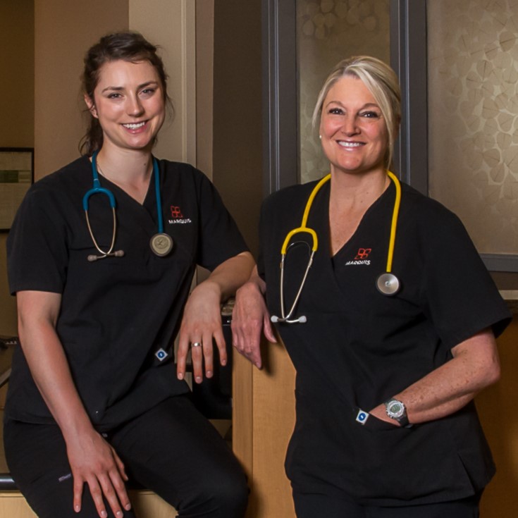 Marquis nurses Two Marquis nurses smiling and standing together with their stethescopes